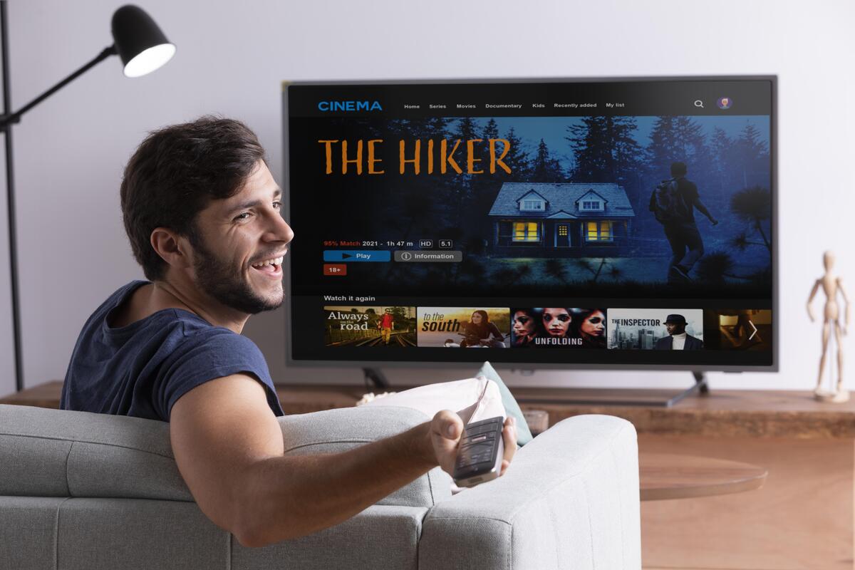 Man watching his favorite movie on a TV using an IPTV player